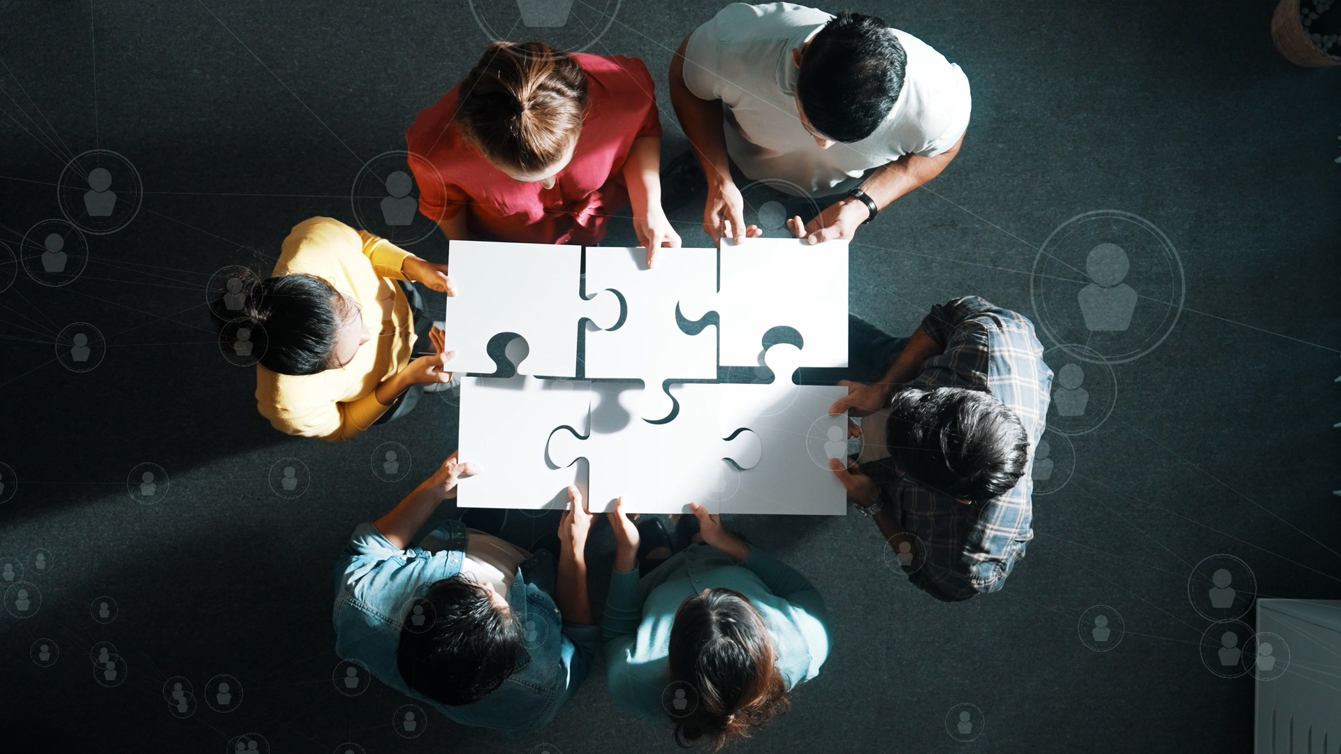 Team members assembling puzzle pieces to represent collaboration and people solutions