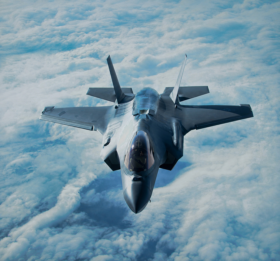fighter jet flying above the clouds