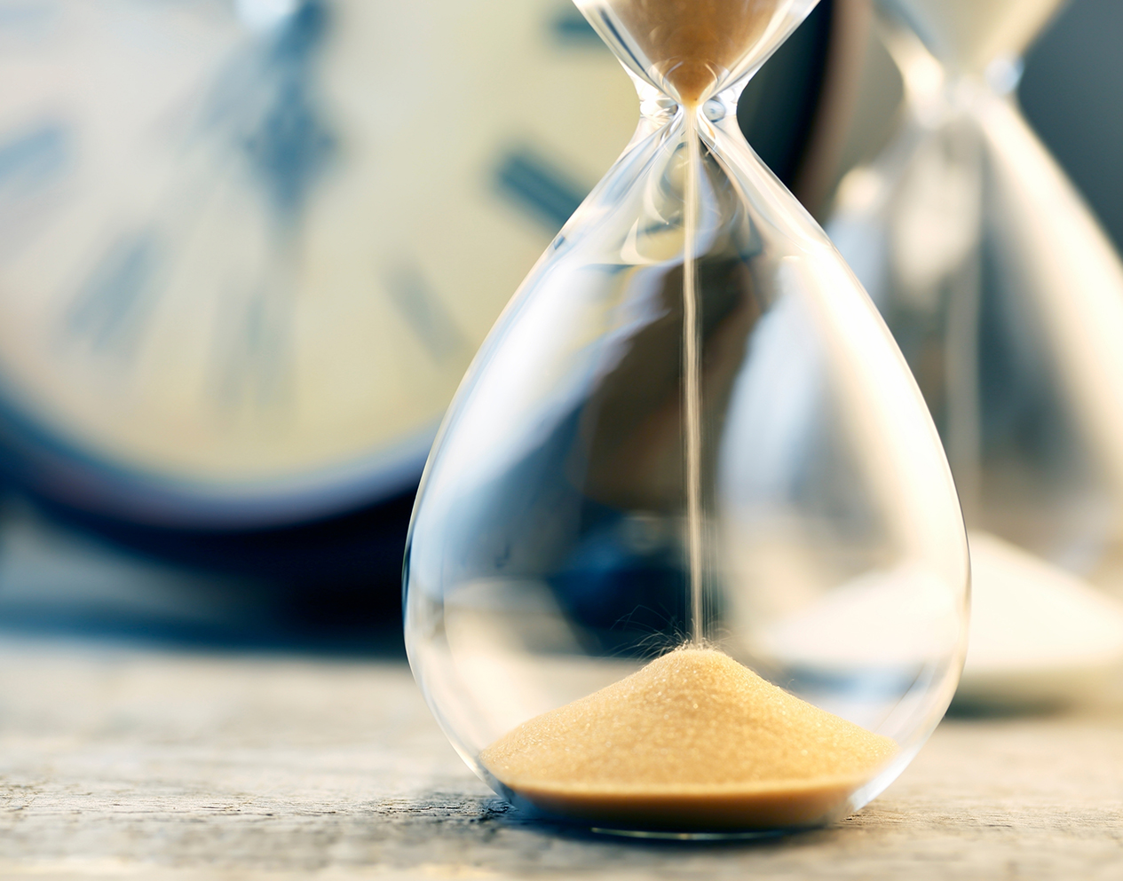 sand inside hourglass dripping to bottom